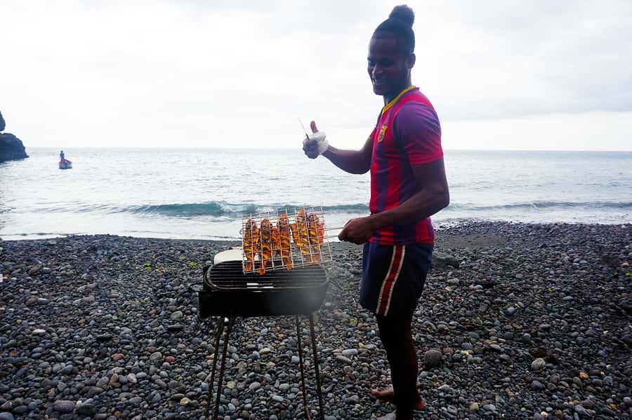 From Praia: Boat Trip, Snorkeling, Cave & BBQ on the Beach - A traditional boat and a volcanic coast
